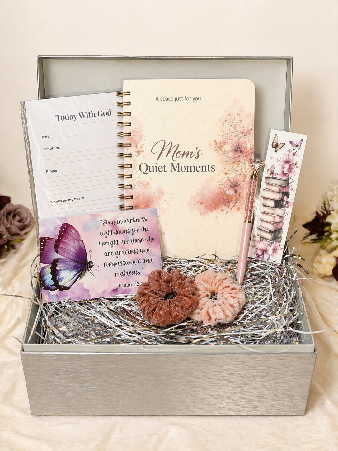 Gift set with 'Mom's Quiet Moments' book, pen, and decorative items in a box.