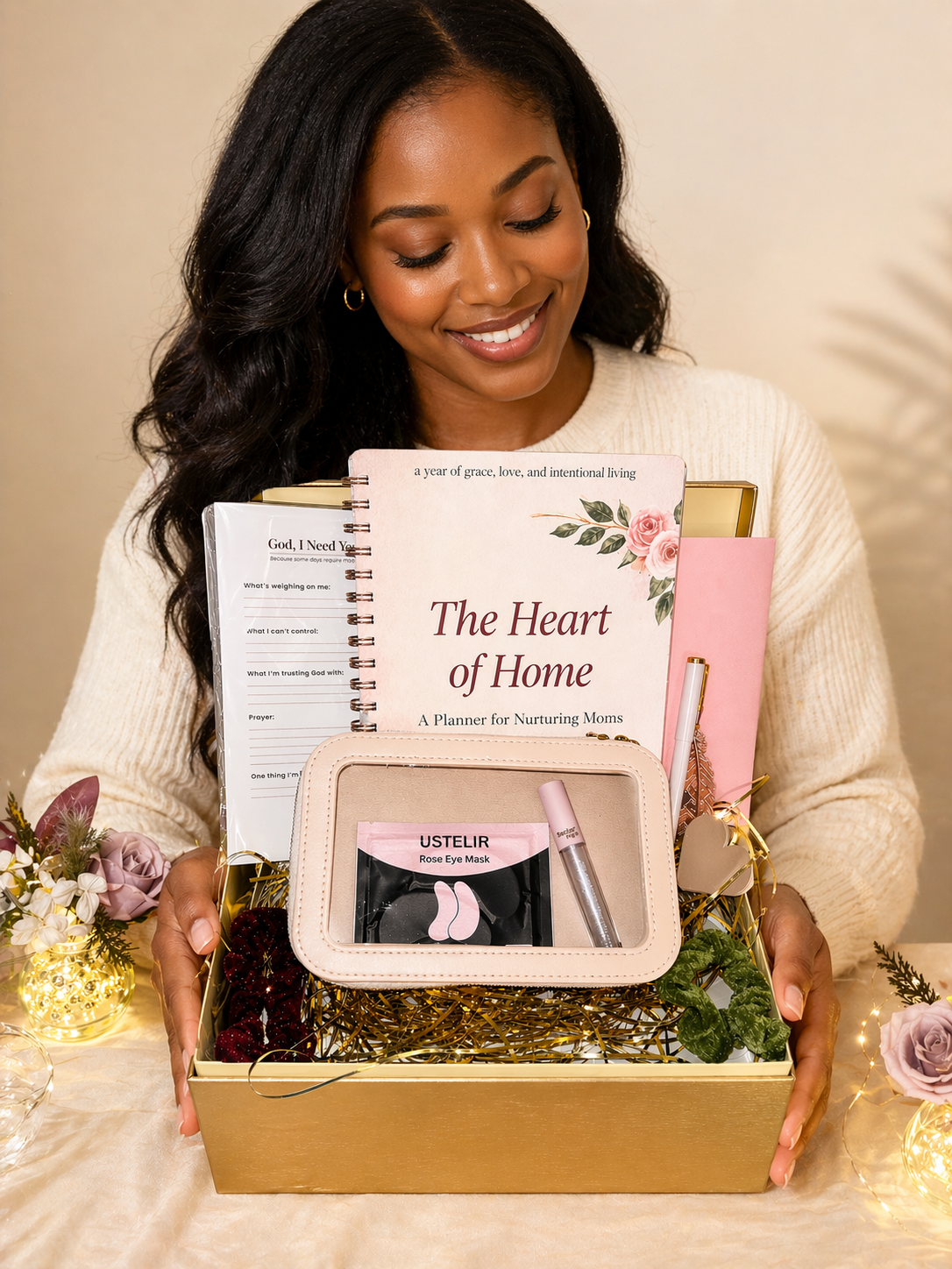 Woman holding a gift box with books and a pouch on a neutral background