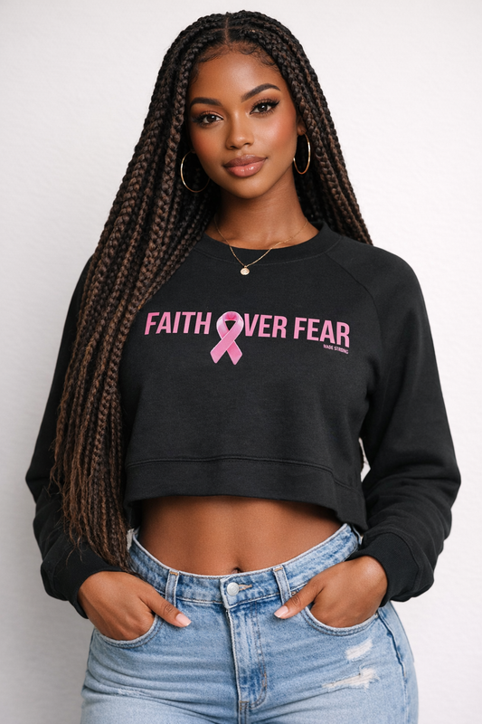 Woman wearing a black sweatshirt with 'Faith Over Fear' and a pink ribbon design.